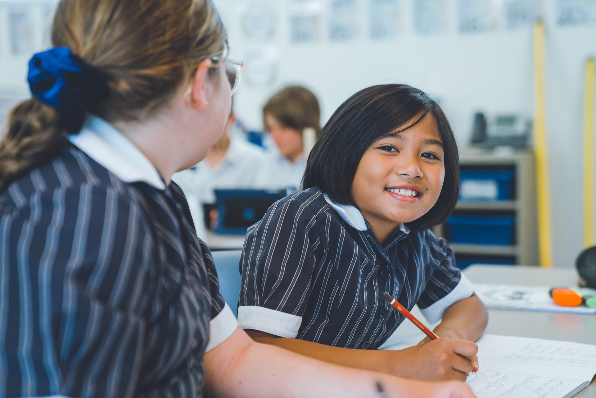 Smiling student completing work in classroom at ACC Darling Downs