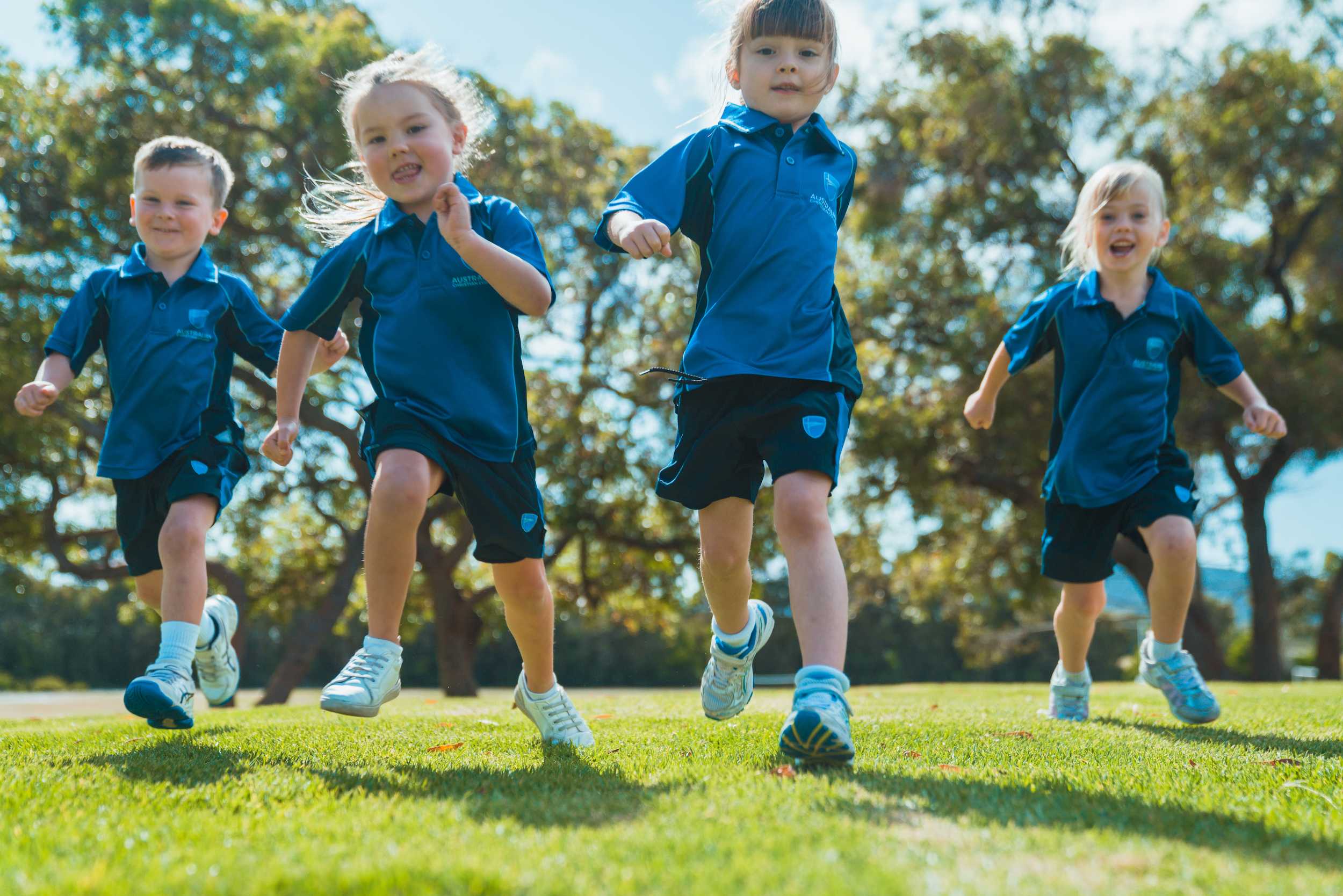 ACC Singleton Kindergarten students wearing sport uniforms, running towards camera