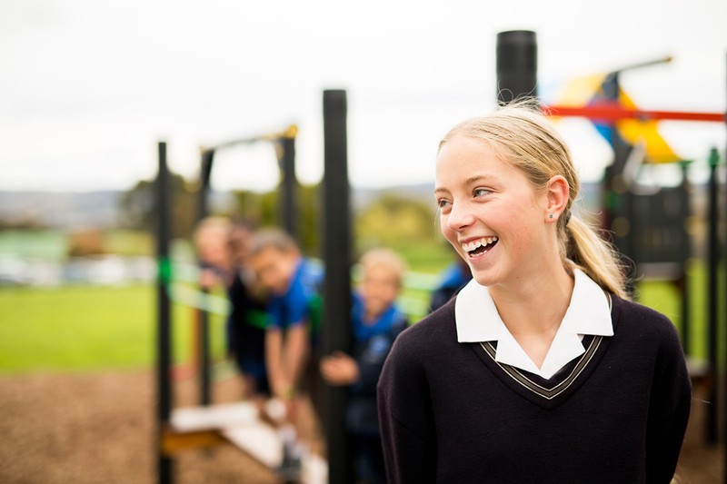 Smiling ACC Benalla secondary school student standing in front of playground