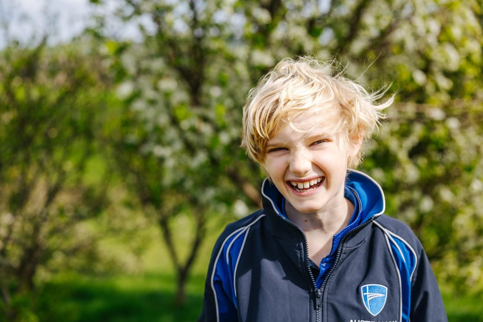 Student laughing outdoors among blossoms at ACC Burnie