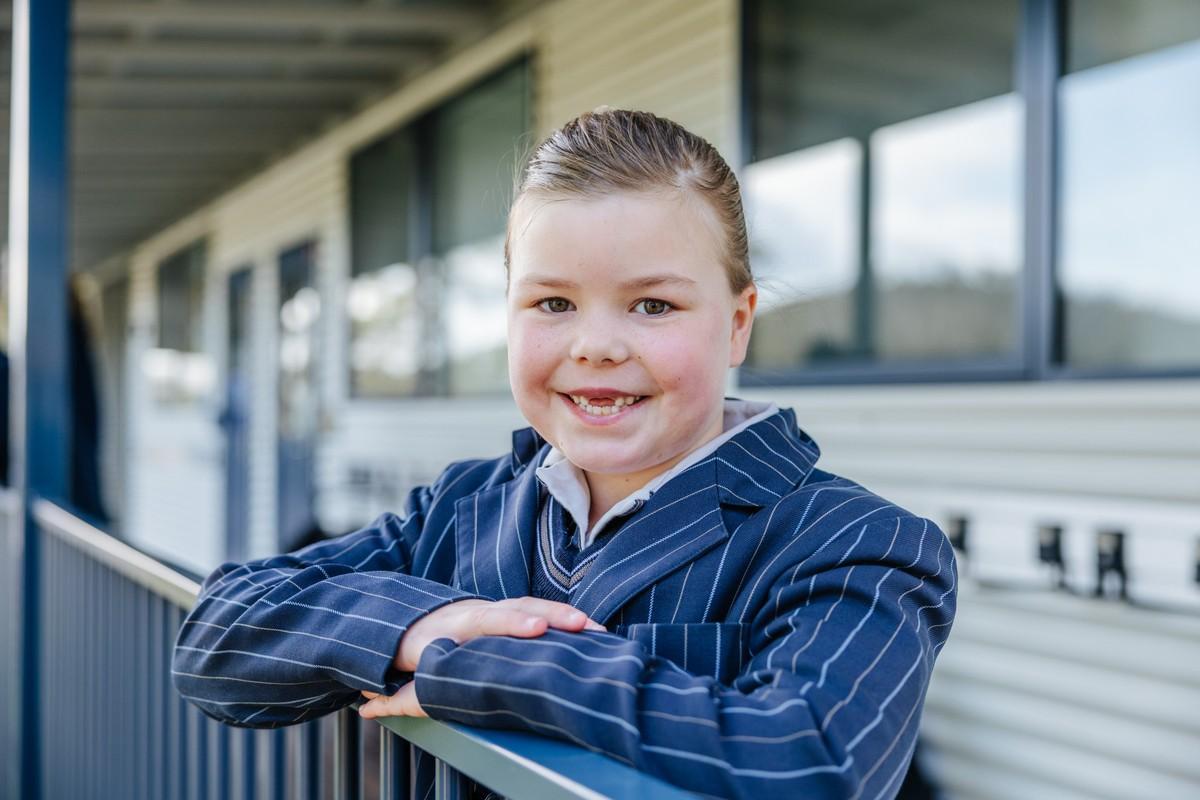 Primary student in uniform on the ACC Hobart campus — tap to book a school tour