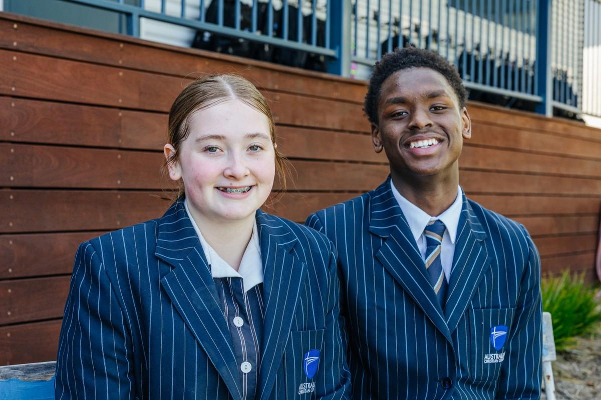 Secondary students smiling in uniform at ACC Hobart — tap to learn about our secondary programme