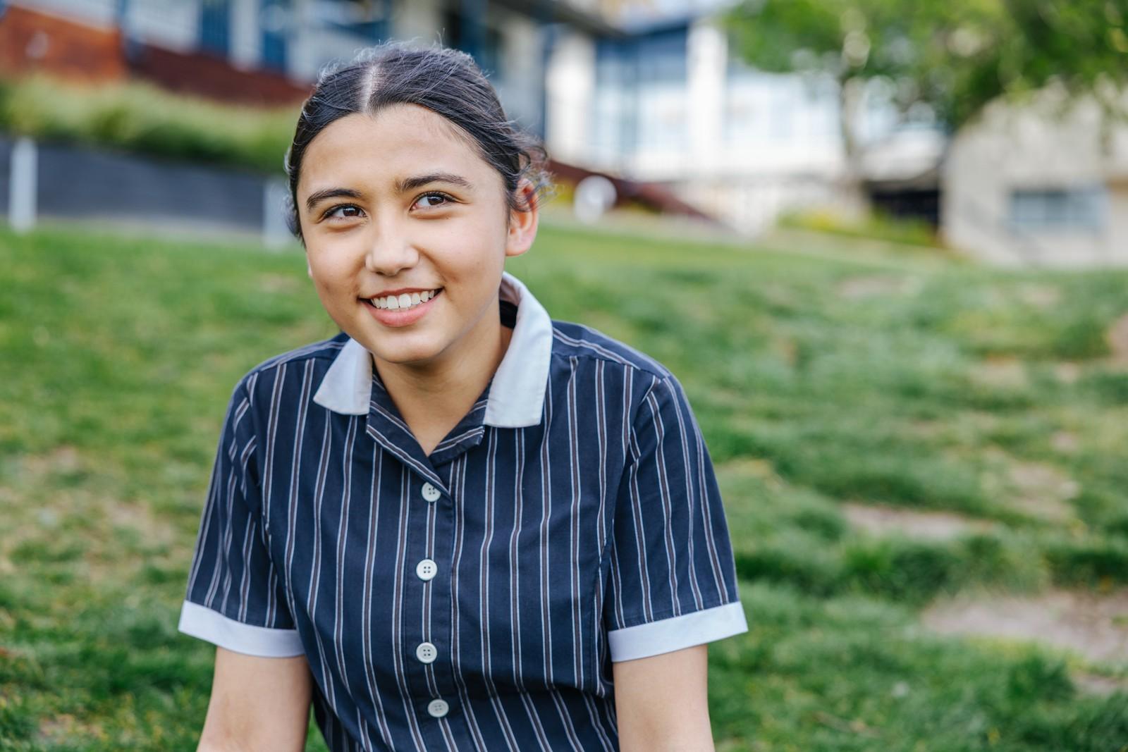 Smiling secondary student in Australian Christian College Hobart uniform on the lawn