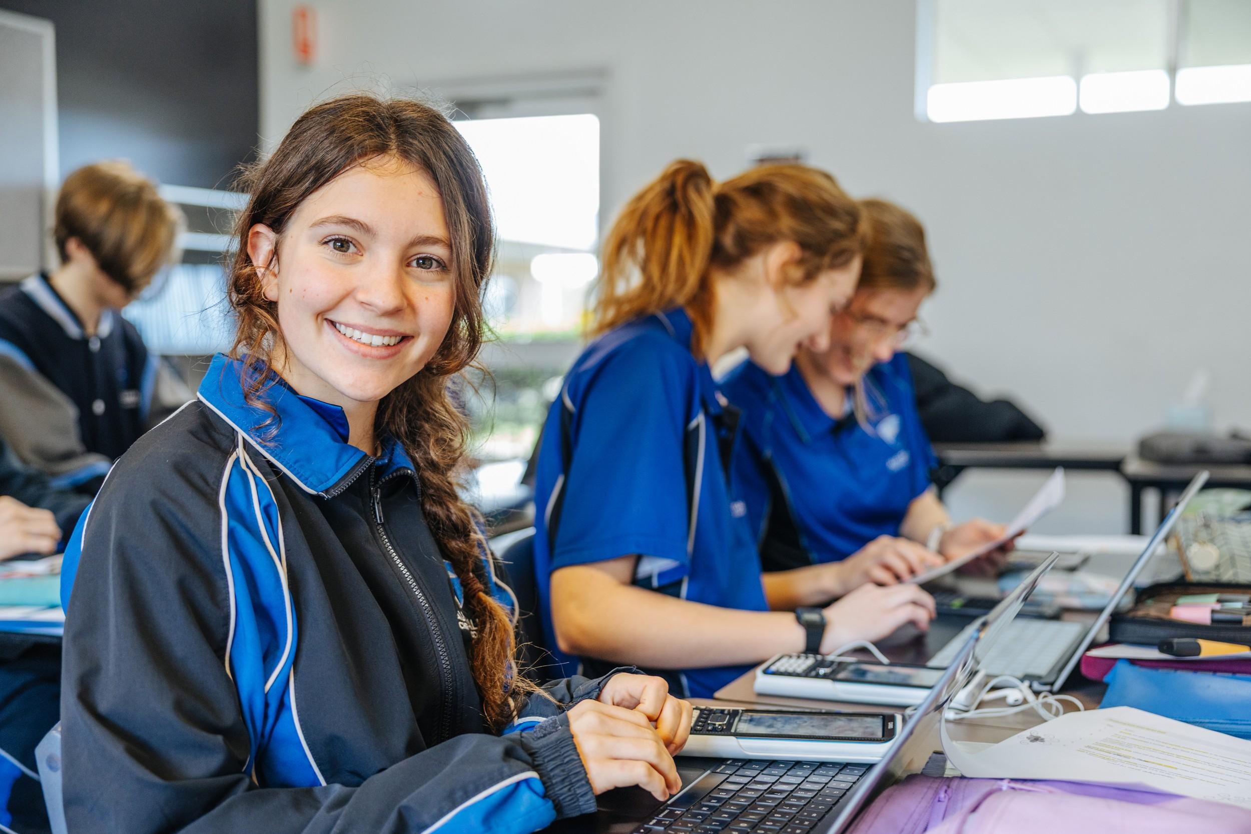 Secondary girl smiling at her laptop in an ACC Southlands classroom
