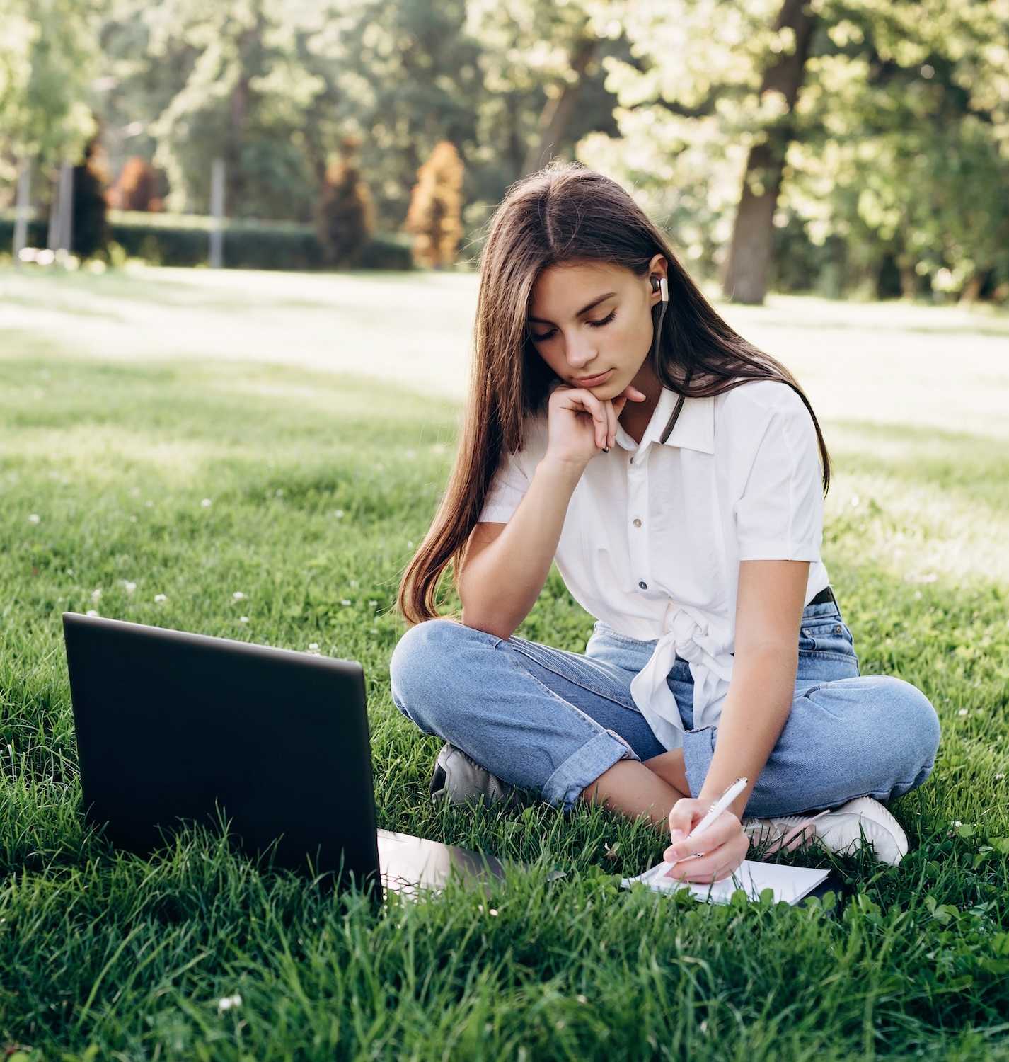 High School aged Victorian student studying on laptop outside